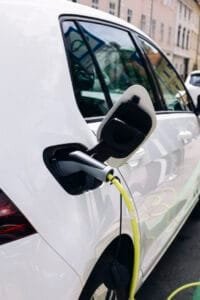 Hvid elbil oplades ved ladestation på gaden