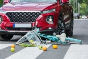 Cykelulykke foran rød bil på fodgængerfelt