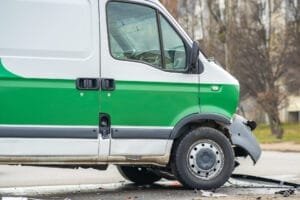 Grøn og hvid varevogn efter trafikuheld