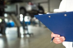 Mekaniker holder clipboard i autoværksted