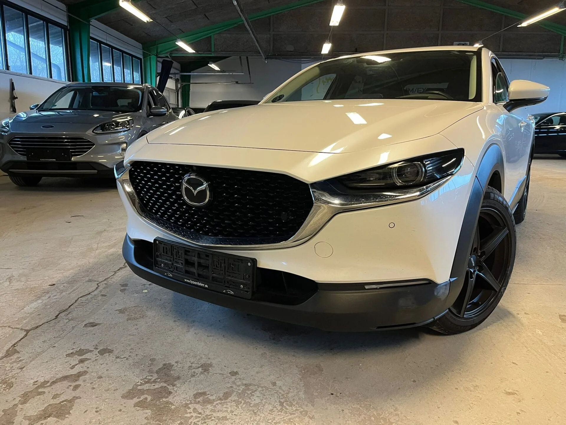 Hvid Mazda SUV parkeret i biludstilling