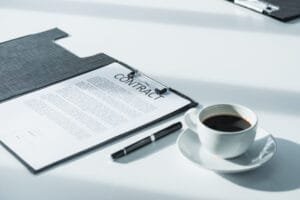 Kontrakt med kuglepen og en kop kaffe