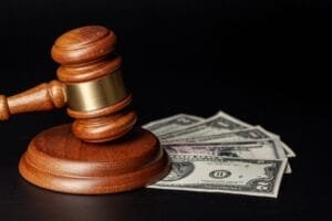 Dommerhammer og dollarsedler på sort baggrund
