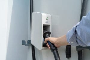 Person oplader elbil ved AC-ladestation