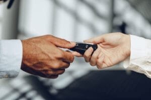 Person giver bilnøgle til en anden person