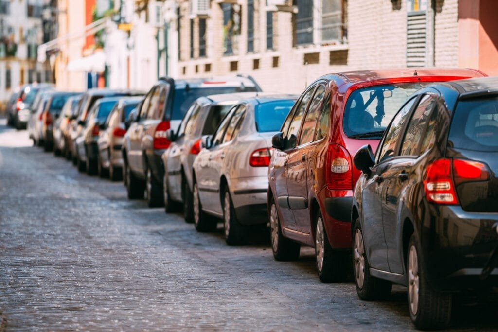Parkerede biler langs en brostensbelagt bygade