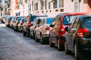 Parkerede biler langs en brostensbelagt bygade