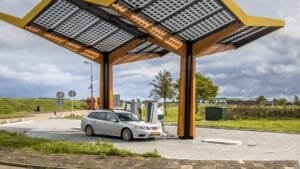 Elbil oplades under solcelletag ved ladestation