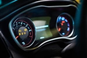Bilens instrumentbræt med advarselslamper og speedometer