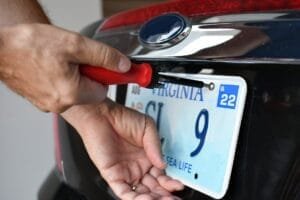 Person monterer nummerplade på bil