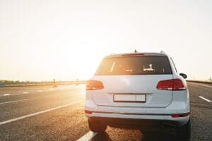 Hvid bil parkeret på solrig motorvej