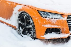 Orange bil dækket af sne og is